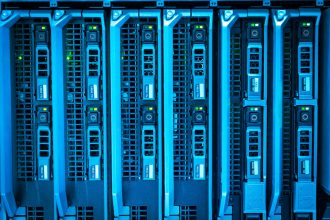 Racks de servidores iluminados em um datacenter, representando infraestrutura de tecnologia da informação.