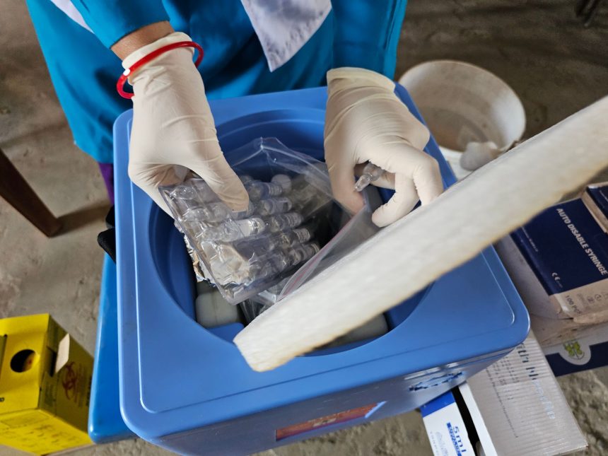 Profissional usando luvas manipula frascos em um laboratório.